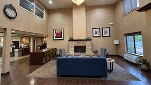 Un espacio habitable amplio con chimenea, candelabro y un ventanal grande.