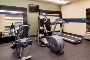 A fitness room with exercise equipment including a stationary bike, elliptical, and treadmill. - Hampton Inn & Suites Orlando/East UCF Area (Orlando)
