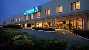 A modern hotel with a large sign reading "Garden City Hotel." It features a spacious entrance with a covered walkway and a well-maintained garden area. - Garden City Hotel, BW Signature Collection (Narrabundah)