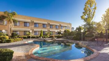 Una piscina al aire libre, tumbonas