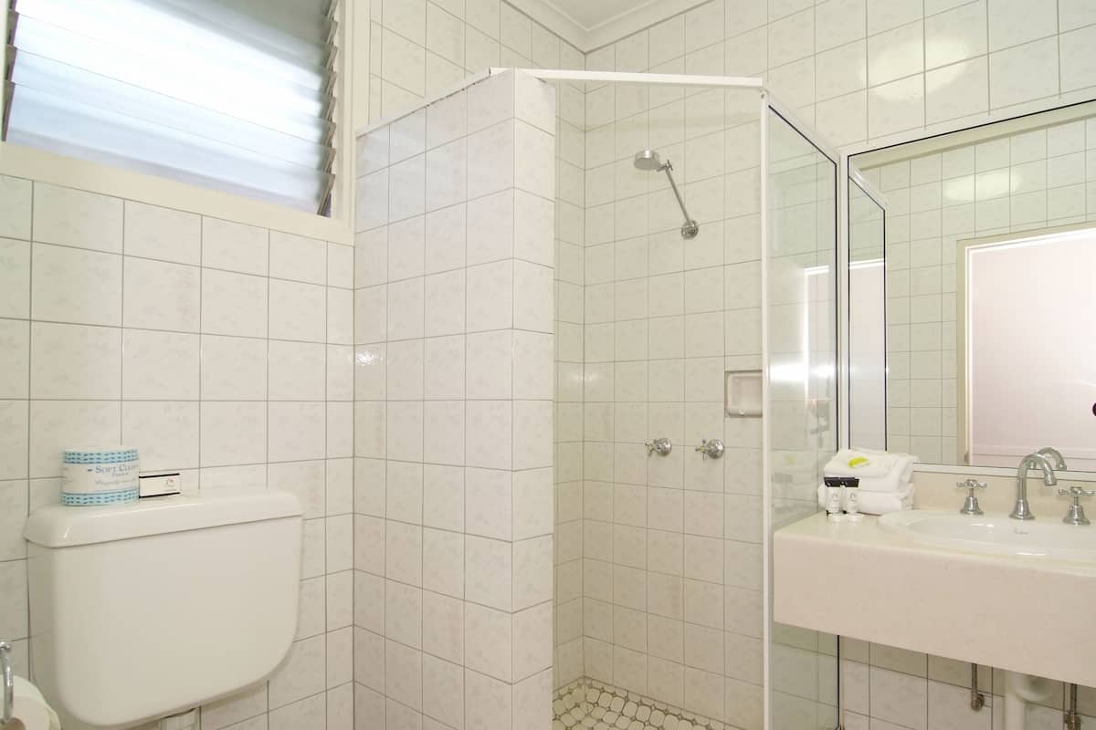 A bathroom with a shower, toilet, and sink.