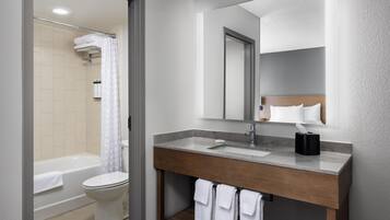 A modern bathroom with a bathtub, toilet, and sink.