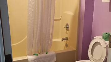 A bathroom with a bathtub, shower, and toilet.