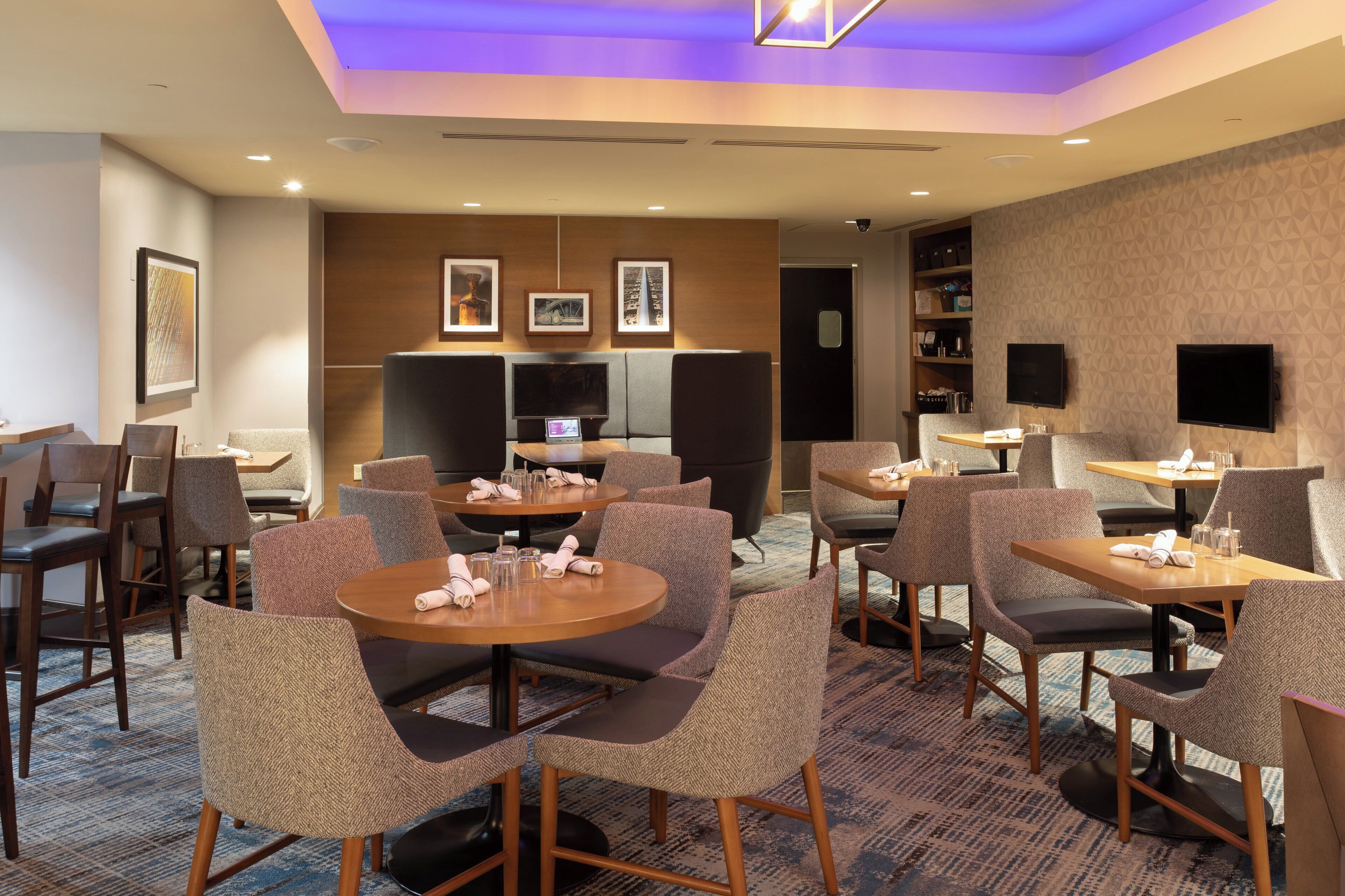 Ein Hotelzimmer mit Essbereich, Fernseher und Minibar.