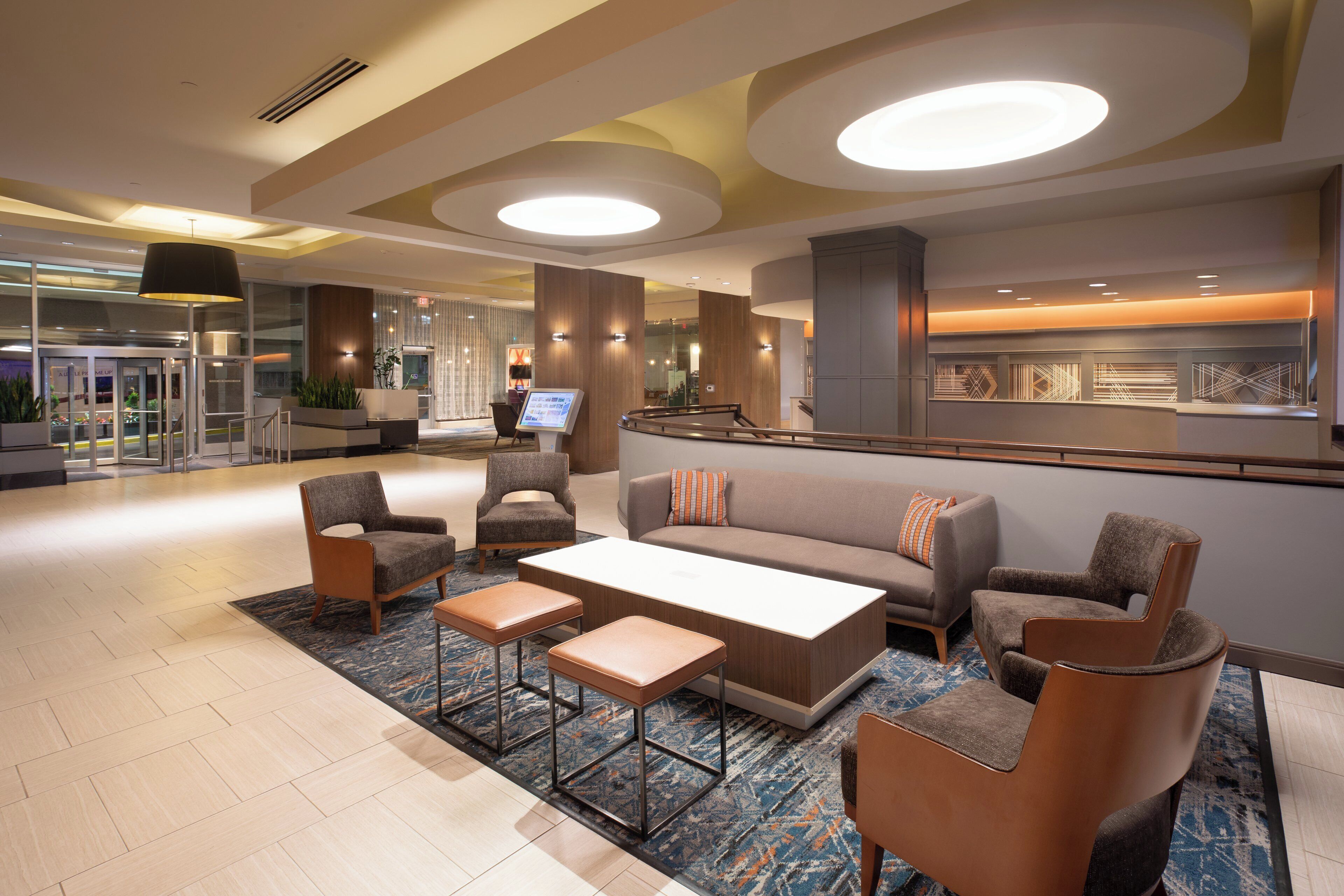 A modern lobby with a seating area, a reception desk, and a glass entrance.