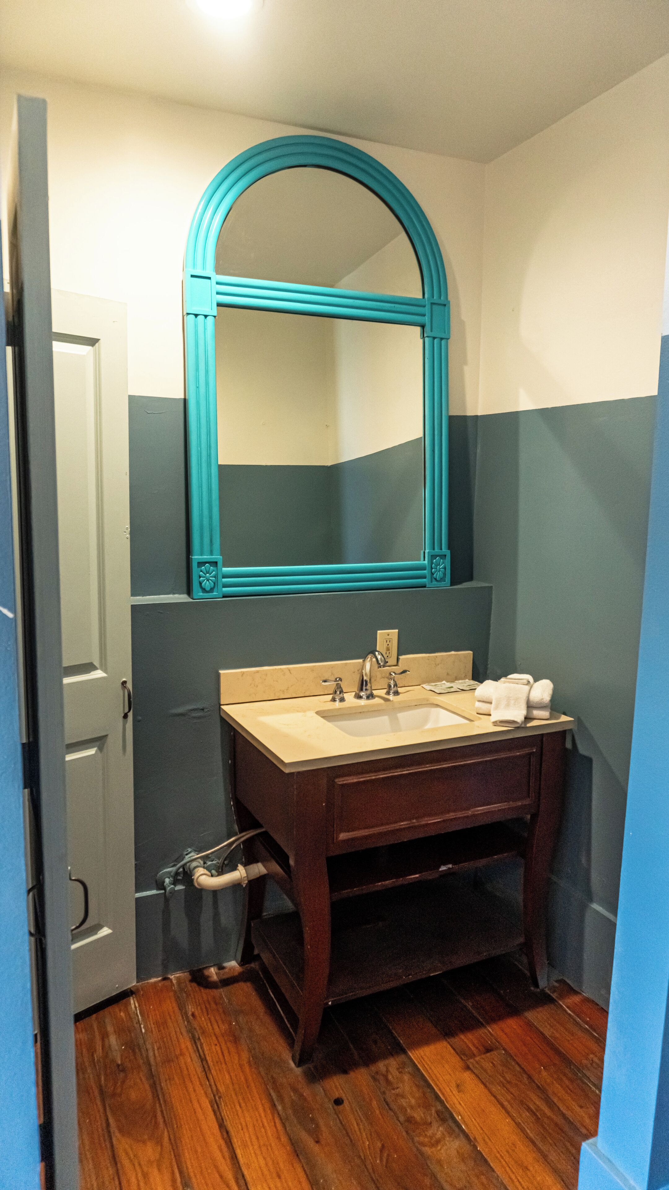 Une salle de bain avec un meuble-lavabo en bois, un évier et un miroir.