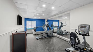 A gym with treadmills, stationary bikes, and a rowing machine.
