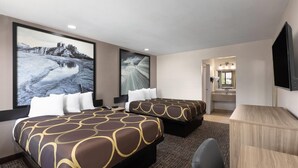 Habitación de hotel con dos camas, un escritorio y un televisor.