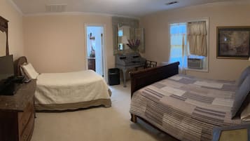 A bedroom with two beds, a dresser, a desk, a mirror, and a window with curtains.