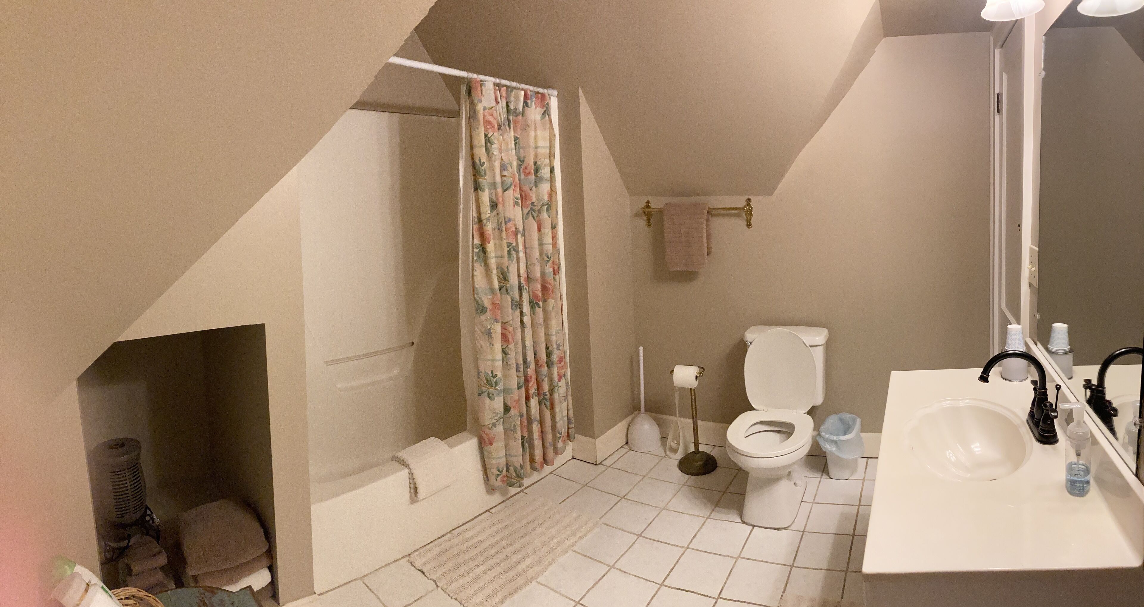 Un bagno con doccia, toilette, lavandino e specchio.