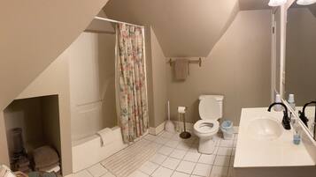 Un bagno con doccia, toilette, lavandino e specchio.