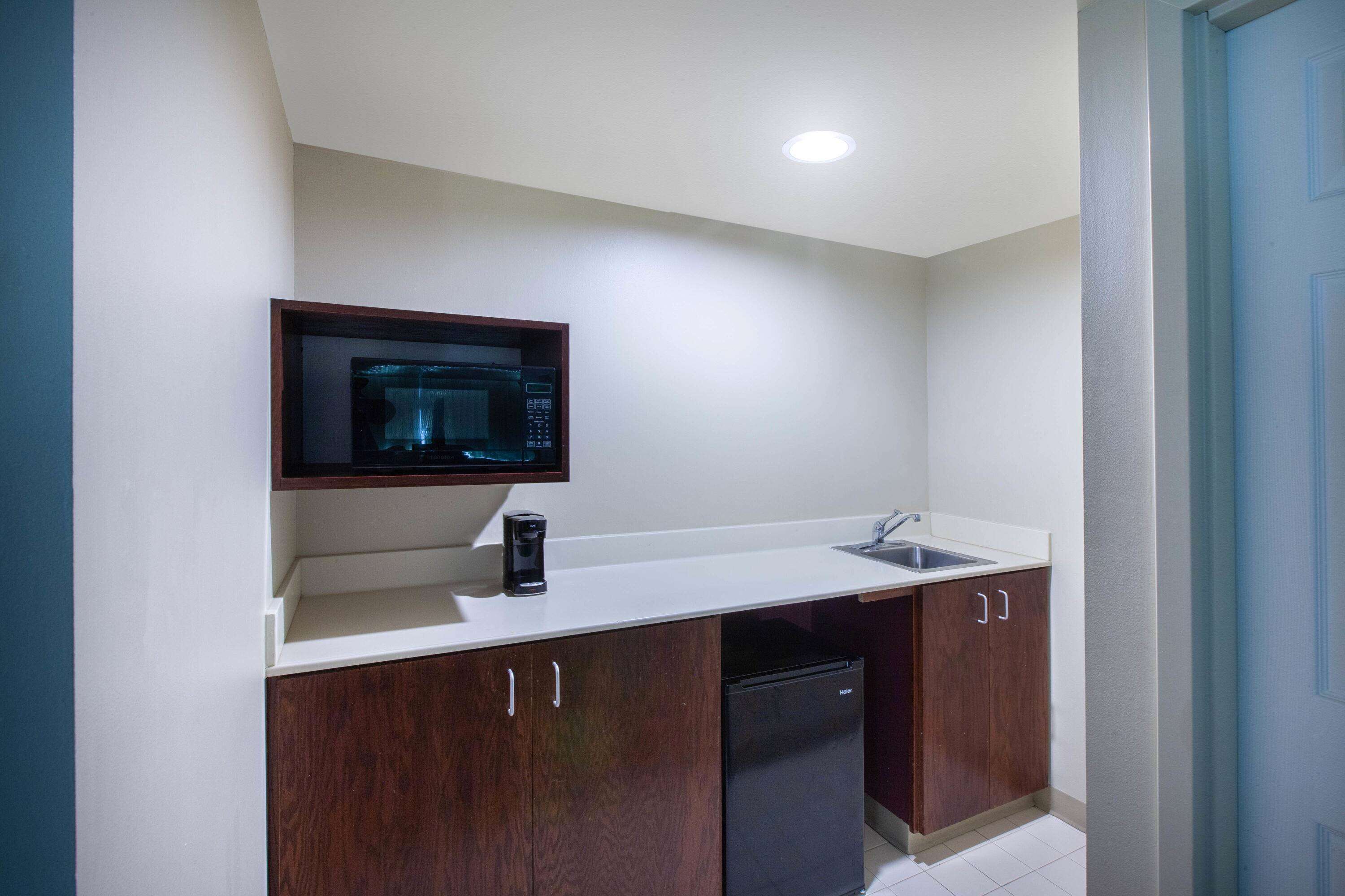 A compact kitchen with a microwave, sink, and dishwasher.