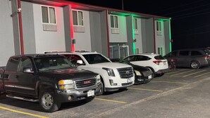 Un parking où sont garés plusieurs camions GMC et un VUS blanc.