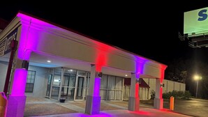 Un hôtel doté d’une entrée couverte et d’une grande enseigne visible à l’arrière-plan.