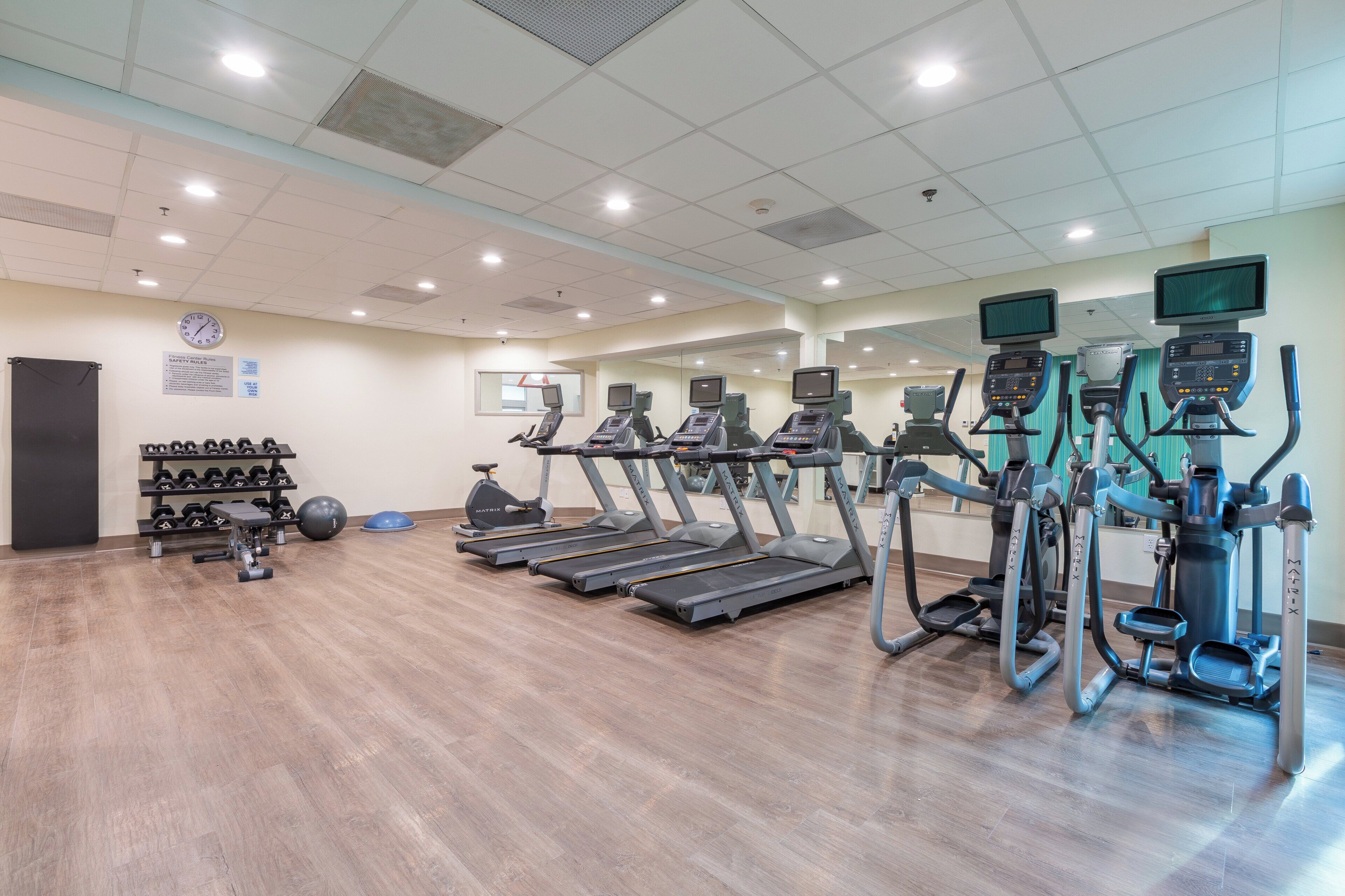 A gym with treadmills, elliptical machines, and weightlifting equipment.