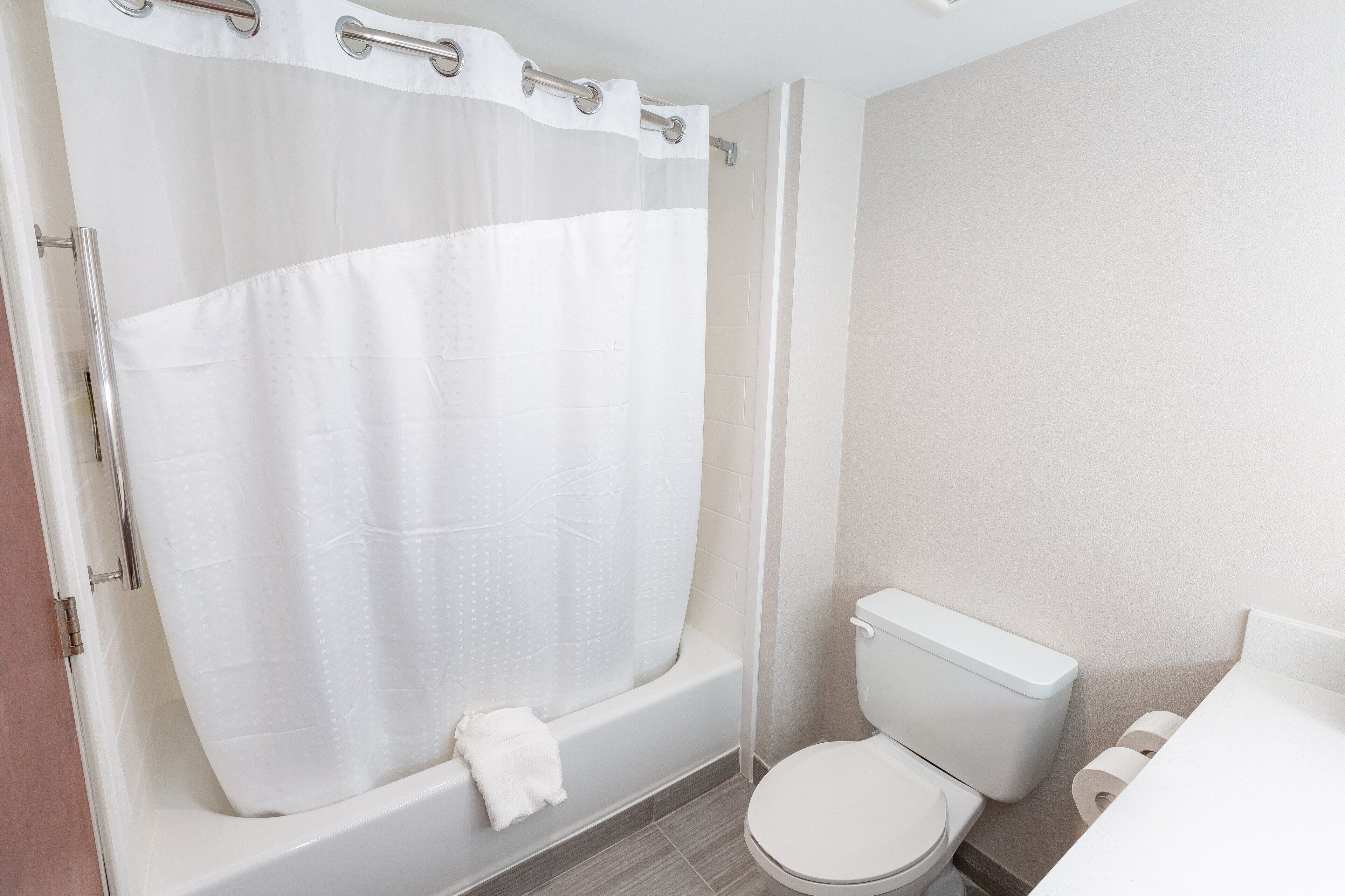 Un baño con bañera, inodoro y cortina de ducha.