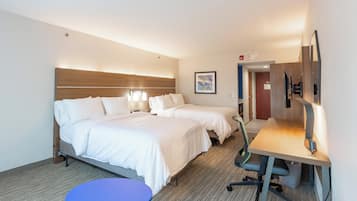 Una habitación de hotel con dos camas, un escritorio, una silla y una mesita redonda.