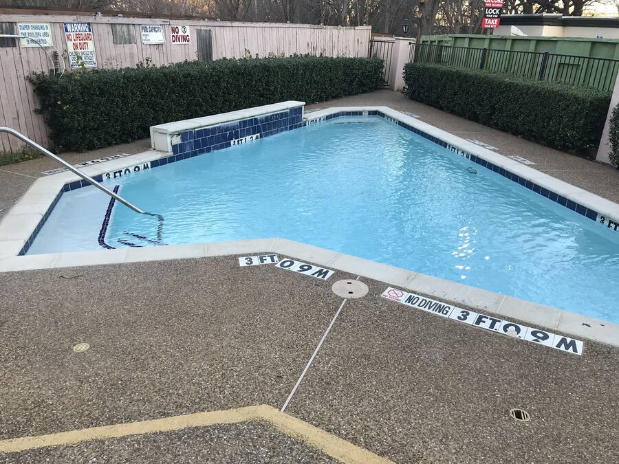 Piscina retangular com azulejos azuis e marcação de profundidade de 90 centímetros.
