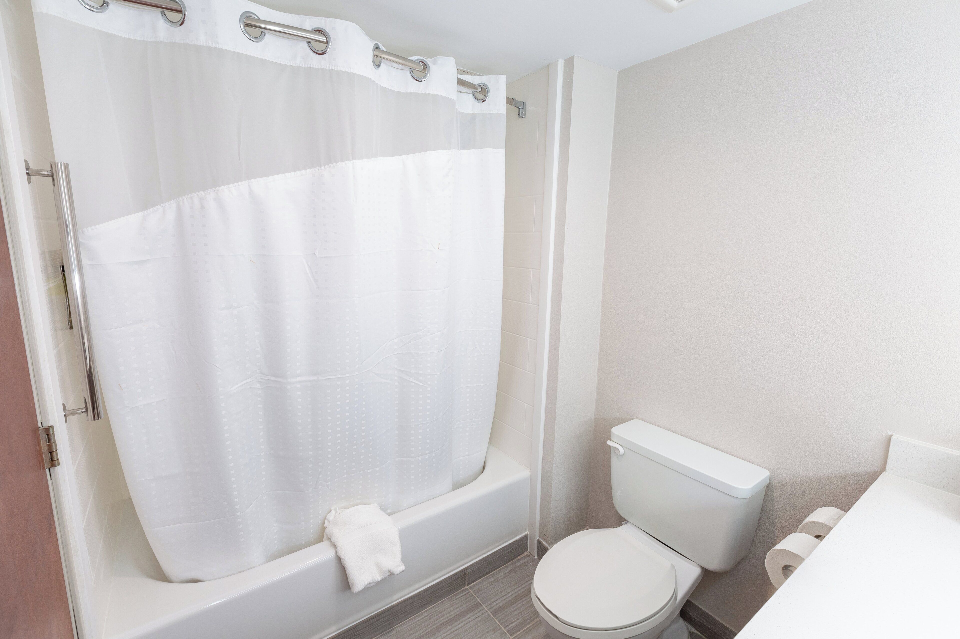A bathroom with a bathtub, toilet, and a shower curtain.