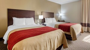 A hotel room with two beds, each with a red and beige bedspread, a nightstand with a lamp, and a window with curtains. - Comfort Inn Horn Lake - Southhaven (Horn Lake)
