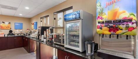 A self-service beverage station with a variety of juices and a refrigerated display case.