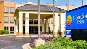 A Comfort Inn hotel with a central entrance, flagpoles, and a blue signboard. - Comfort Inn Horn Lake - Southhaven (Horn Lake)