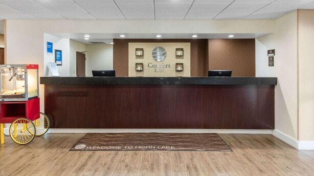 A hotel reception desk with a sign reading "Comfort Inn" and a welcome mat that says "Welcome to Horn Lake." - Comfort Inn Horn Lake - Southhaven (Horn Lake)