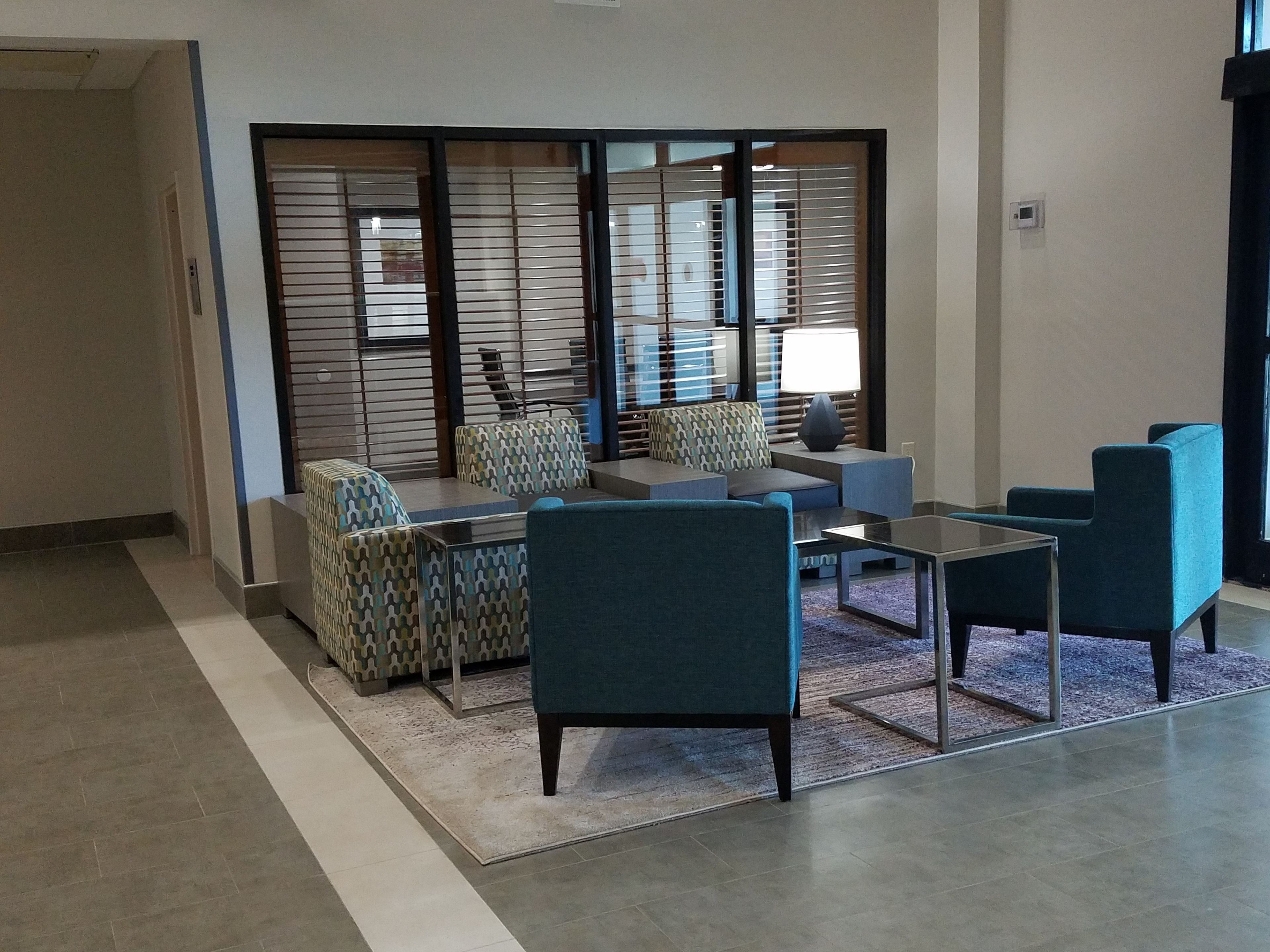 A modern lounge area with seating arrangements, a coffee table, and a decorative partition.