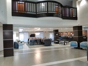 A spacious lobby with a curved balcony, a bar area, and seating arrangements. - Comfort Inn & Suites Columbus North (Columbus)