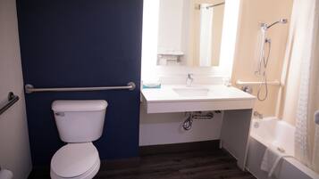 Une salle de bain avec des toilettes, un lavabo et une douche.