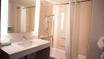 Une salle de bain avec deux éviers, une baignoire et une douche avec un rideau.