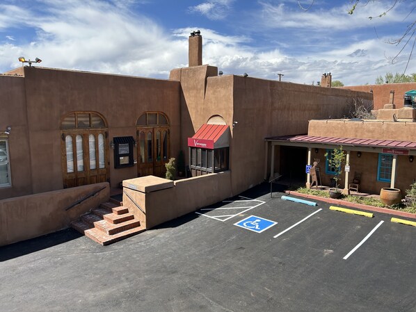 A parking lot with a handicapped parking space, a staircase leading to a building with a red awning, and a sign for 'Vonnessie'.