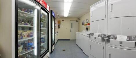 A laundry room with a refrigerator and stacked washing machines.