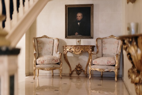A room with two ornate chairs, a small table, and a framed portrait on the wall. - Hotel Manos Stephanie (Brussels)