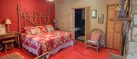 A bedroom with a bed, a chair, a wooden headboard, a nightstand, a lamp, and a wardrobe.