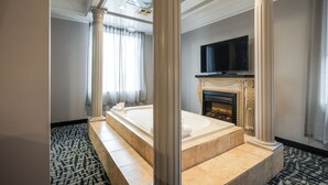 A spacious bathroom with a large bathtub, a fireplace, and a flat-screen TV. - Monte Carlo Inn Toronto West Suites (Mississauga)