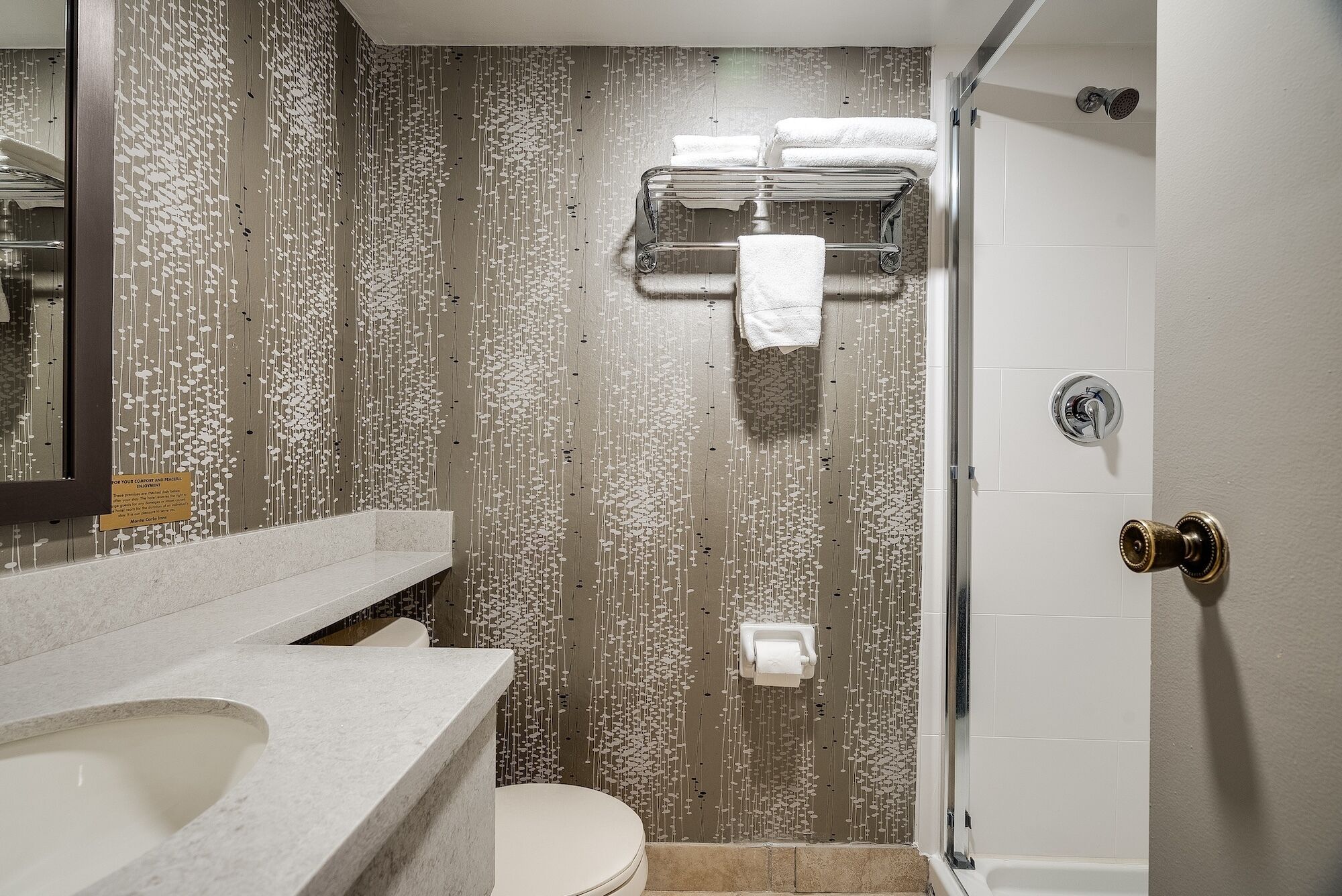 Un baño moderno con ducha, inodoro y lavamanos.