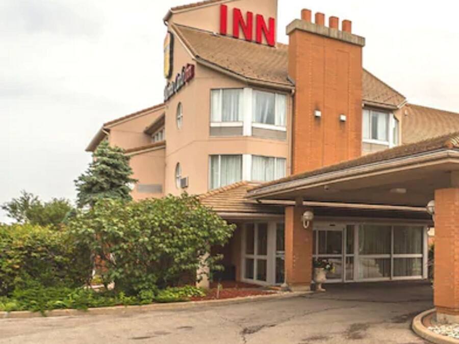A hotel with a prominent 'INN' sign, a covered entrance, and a brick facade.