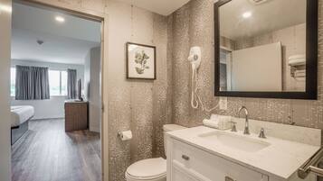 A modern bathroom with a large mirror, a hairdryer, and a toilet.