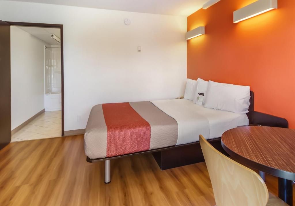 Una habitación de hotel con una cama, una mesa redonda y una silla.