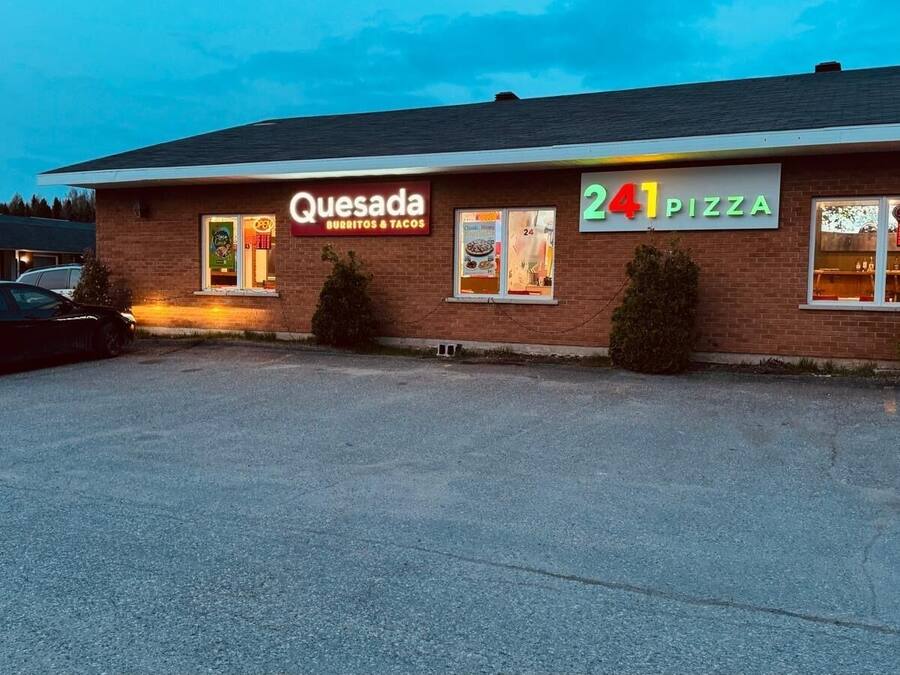 A Quesada Burritos & Tacos and 241 Pizza restaurant with a parking lot in front.