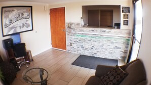 A reception area with a wooden door, a tiled counter, and a framed picture on the wall. - Super 8 by Wyndham McGehee (McGehee)
