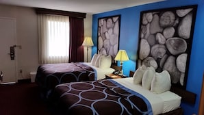 A hotel room with two beds, a nightstand, a lamp, and artwork on the walls. - Super 8 by Wyndham McGehee (McGehee)