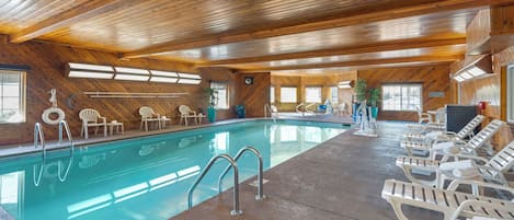 Interior de fusta amb una piscina, gandules i un sostre amb gots de llum.