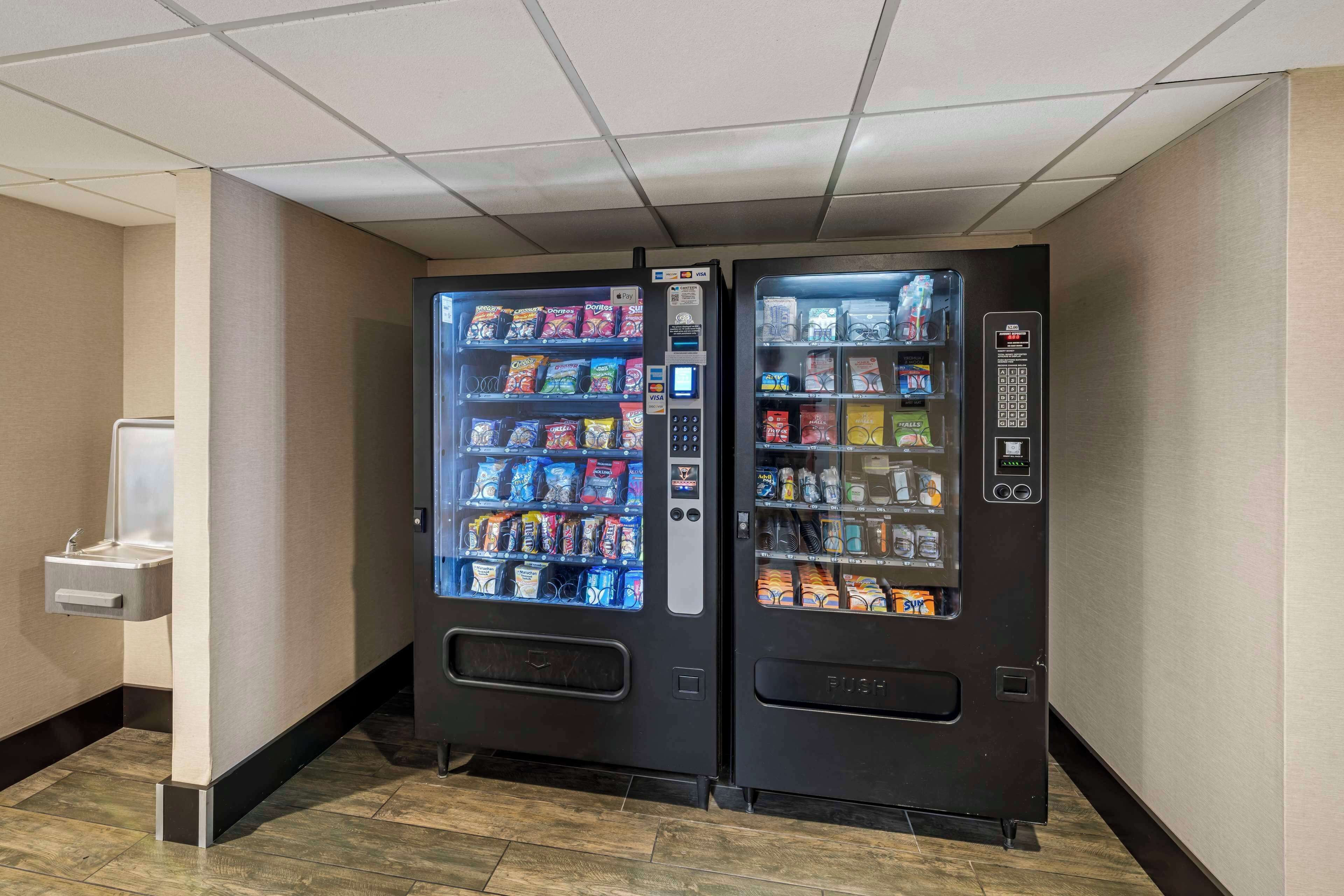 A vending machine with snacks and drinks in a hallway.