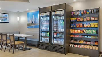 A hotel lobby with seating, two beverage vending machines, and snack shelves.
