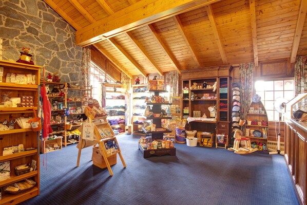 Un interior rústico con vigas de madera, paredes de piedra y estantes llenos de objetos diversos.