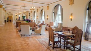 A spacious lobby with a checkered floor, elegant chandeliers, and a dining area with wooden furniture. - Digby Pines Golf Resort and Spa (Digby)