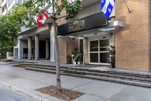 L’entrée d’un hôtel, avec une enseigne indiquant « HÔTEL SAINT-LAURENT MONTREAL » et un drapeau.