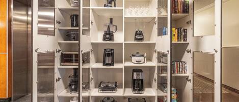 A kitchenette with various appliances and storage shelves.